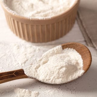 Xanthan Gum in a wooden bowl and on a wooden spoon