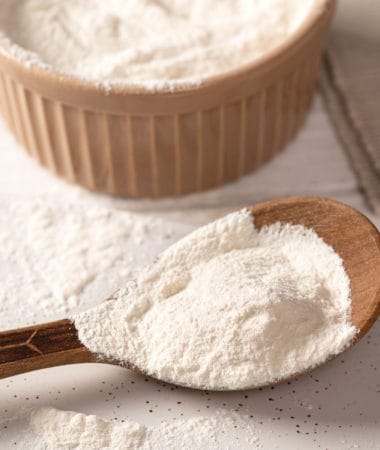 Xanthan Gum in a wooden bowl and on a wooden spoon