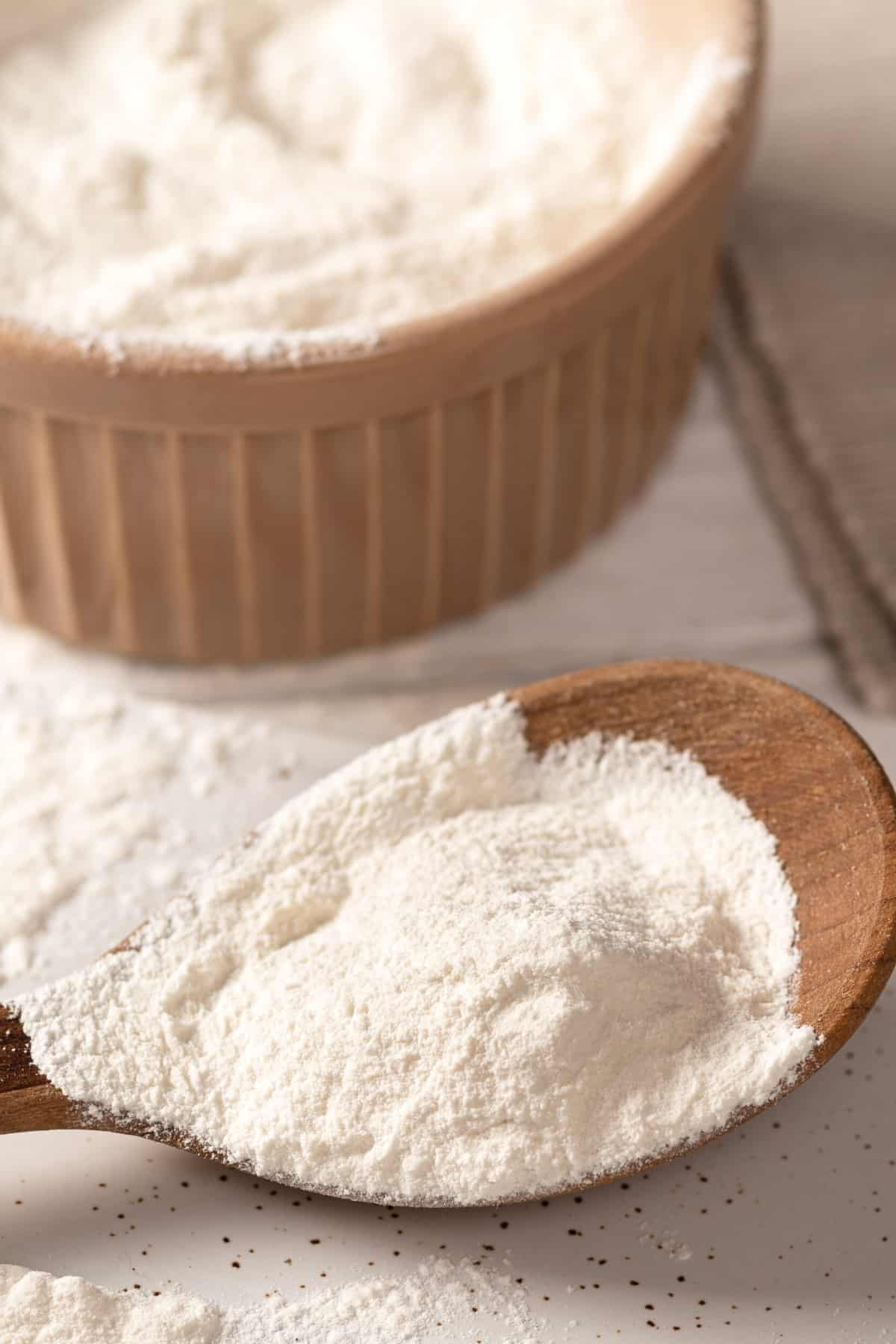 Xanthan Gum on a wooden spoon and in a wooden bowl