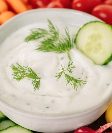 Greek yogurt ranch in a bowl surrounded by vegetables