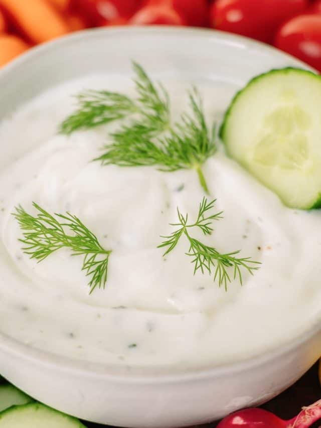 Greek yogurt ranch in a bowl surrounded by vegetables