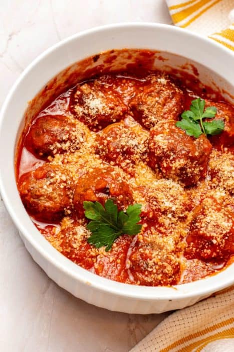 Frozen Meatballs with marinara sauce topped with parsley and cheese