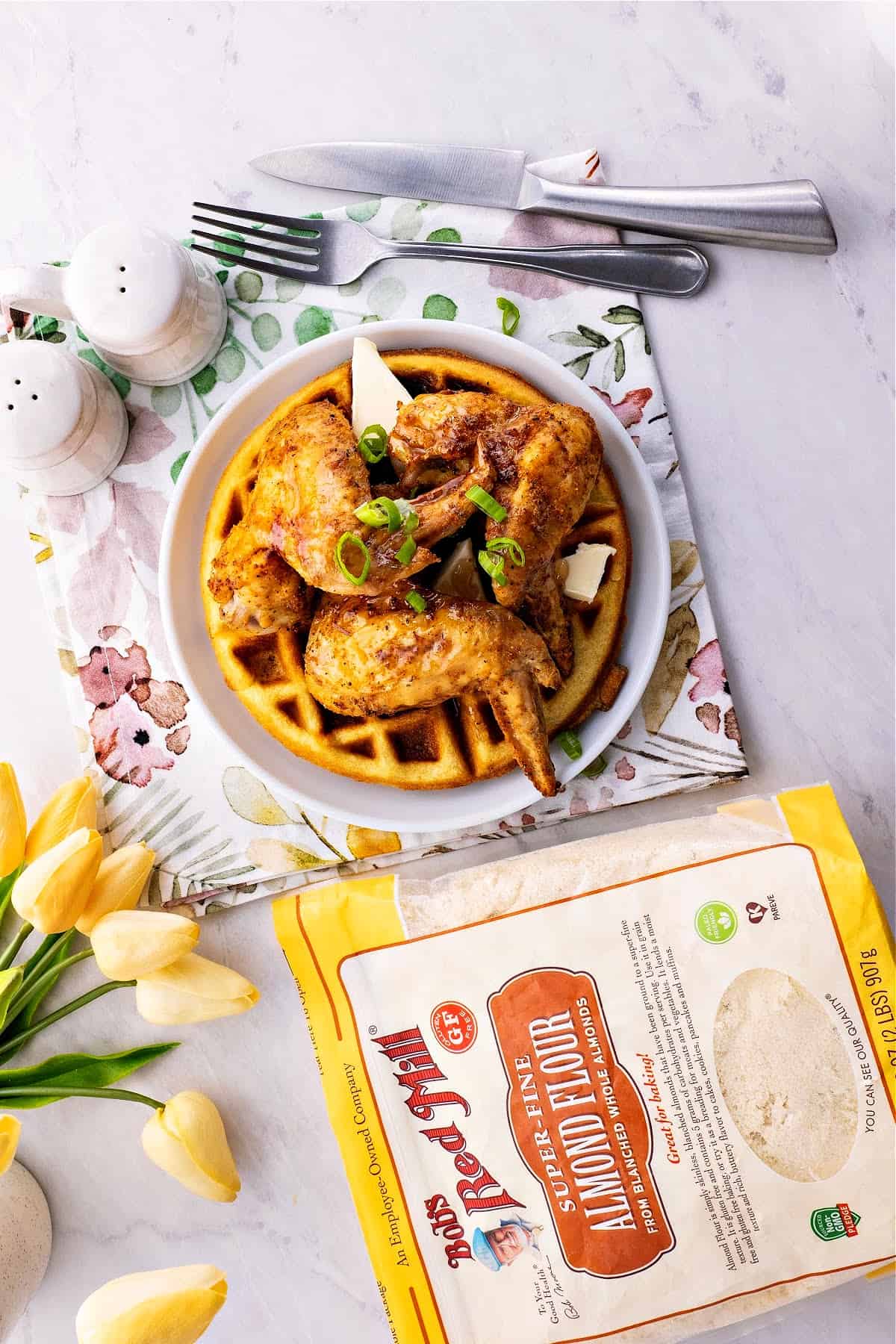 Keto Chicken and Waffles plated beside a pack of almond flour