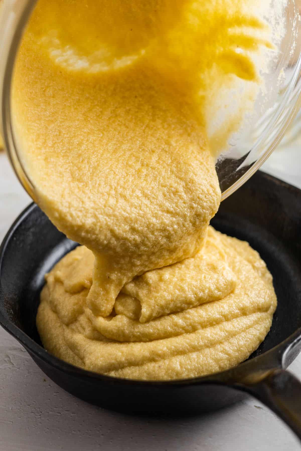 pouring cornbread mixture on a small pan