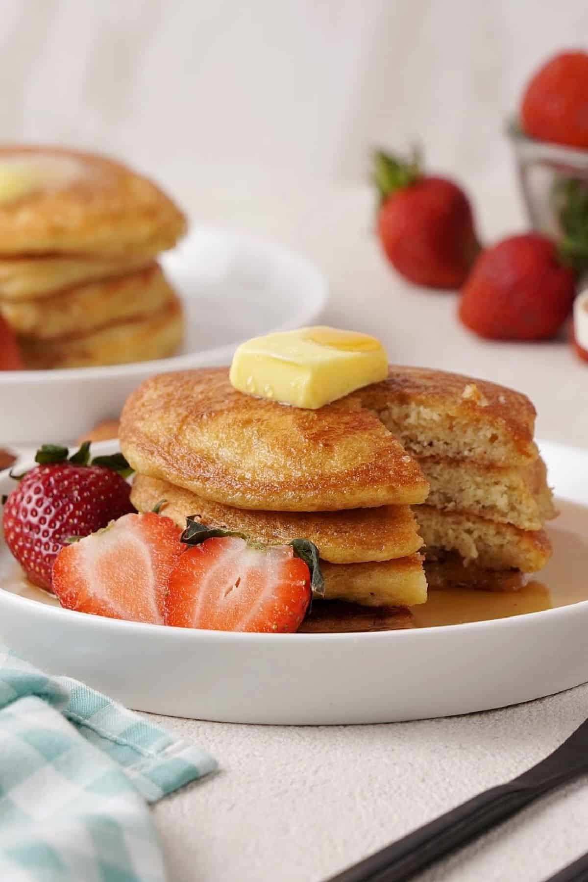almond flour Pancakes recipe with strawberries on a plate and topped with butter