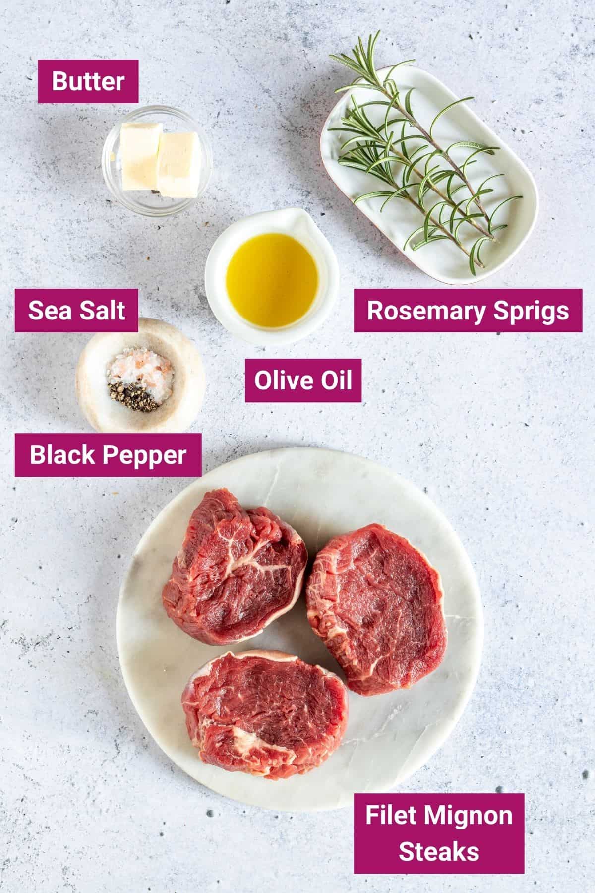 butter, rosemary, sea salt, black pepper, olive oil and mignon steaks on separate plates and bowls