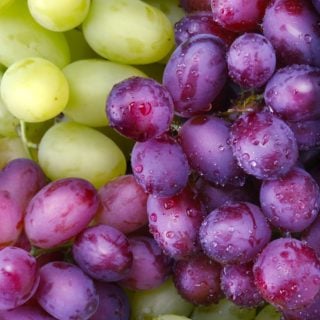 a bunch of green and purple grapes