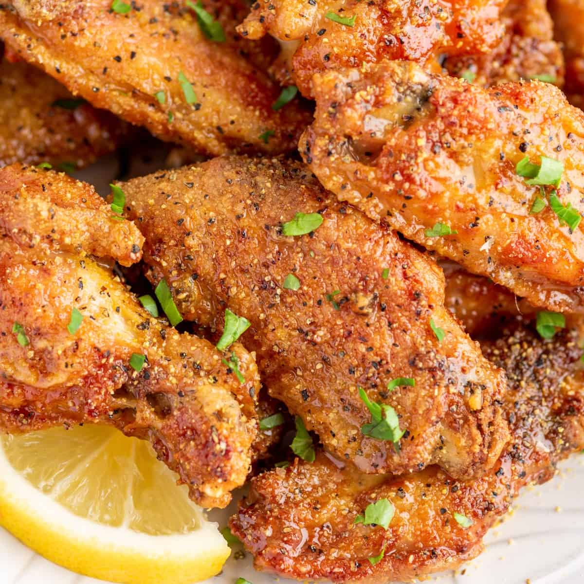 lemon pepper wings on a plate with a slice of lemon