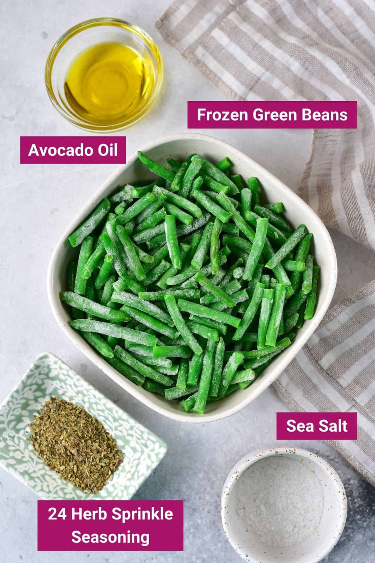 ingredients needed to make air fryer frozen green beans: frozen green beans, avocado oil, sea salt and 24 herb sprinkle seasoning in separate bowls