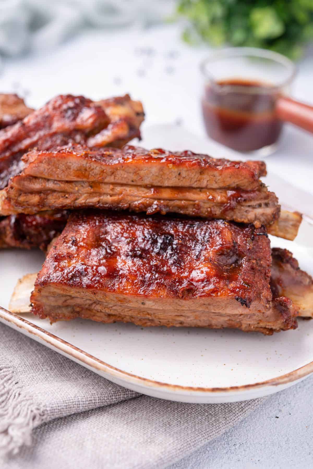 close up shot of Air Fryer Ribs on a plate with bbq sauce