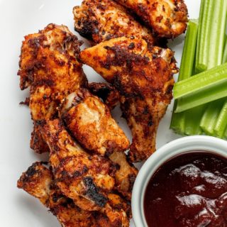 frozen wings cooked in an air fryer on a plate with celery and bbq sauce
