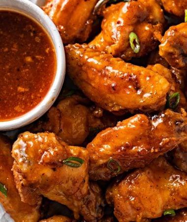 ghost pepper wings on parchment paper with ghost pepper sauce