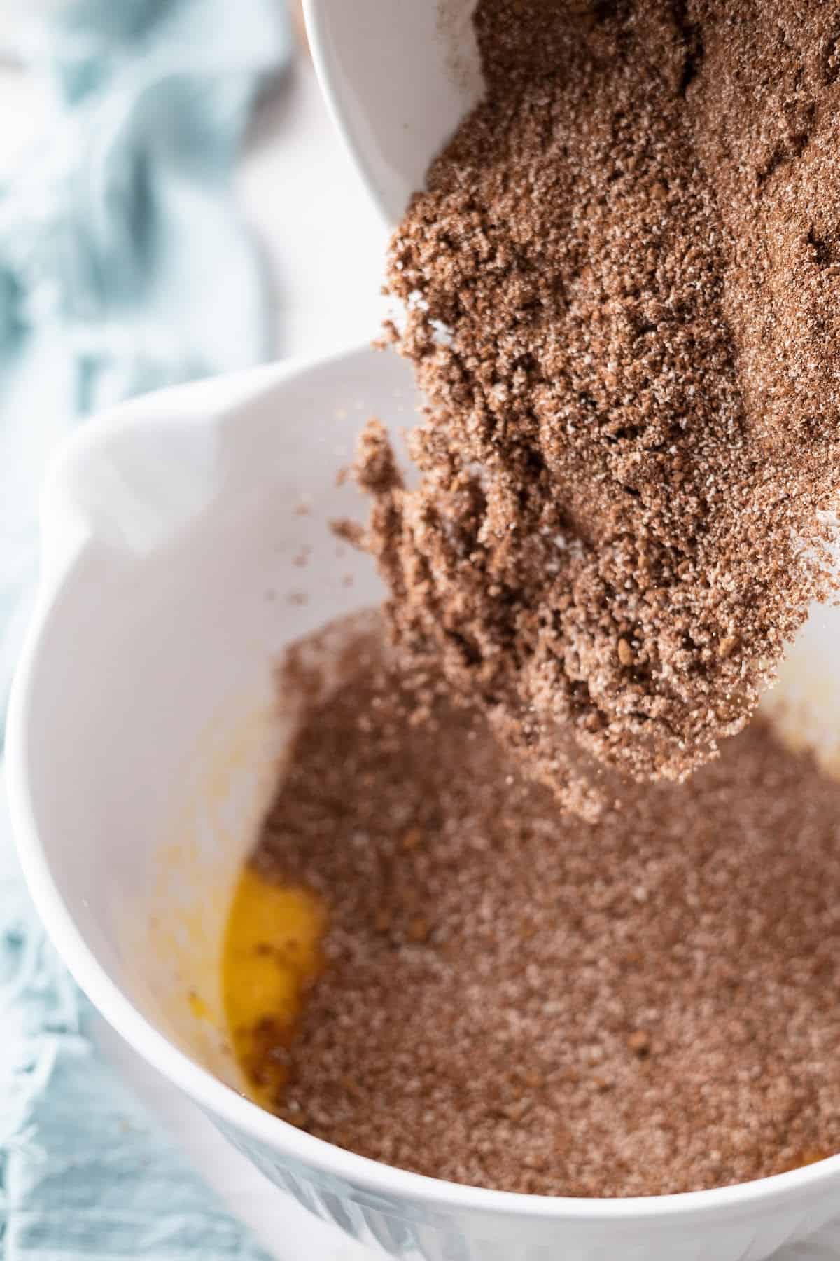 almond flour brownies dry mix being poured into wet ingredients