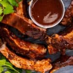 fall off the bone ribs on a plate with bbq sauce