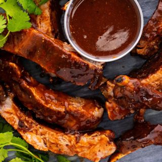 fall off the bone ribs on a plate with bbq sauce