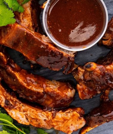 fall off the bone ribs on a plate with bbq sauce