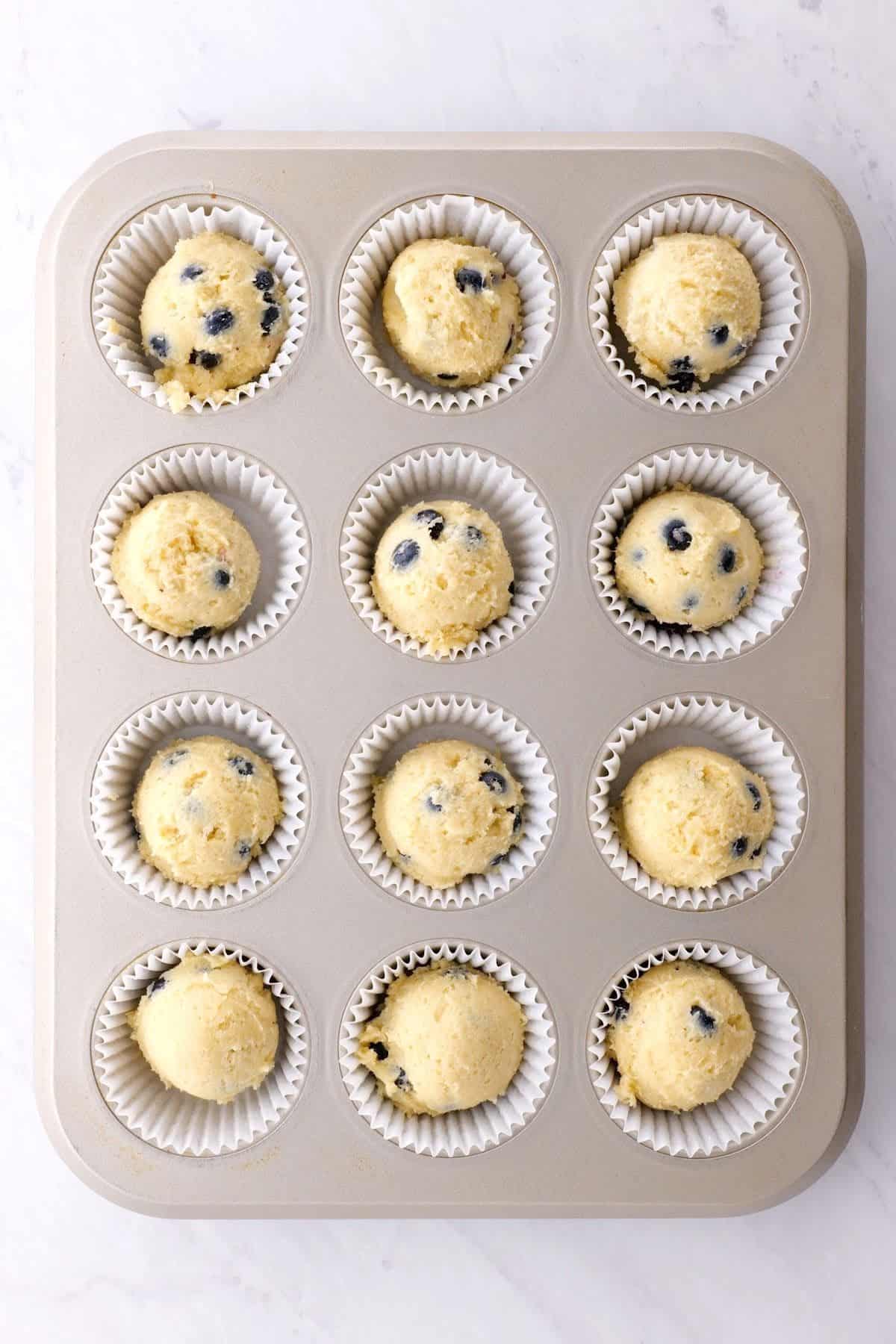 blueberry batter in a muffin pan