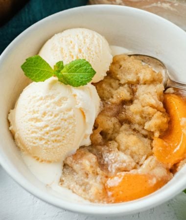 close up shot of Peach Cobbler with vanilla ice cream