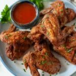 crispy air fryer whole chicken wings and sauce on a plate