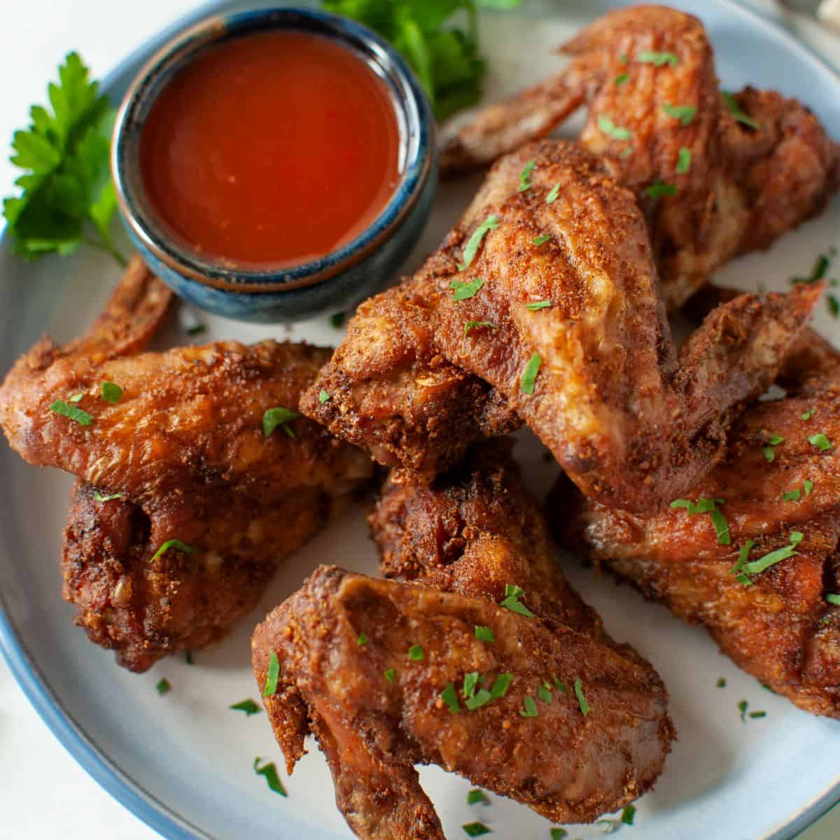 crispy air fryer whole chicken wings and sauce on a plate