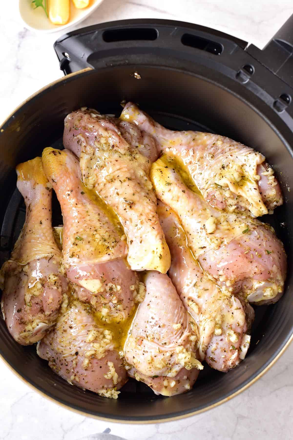 marinated drumsticks in an air fryer ready for cooking