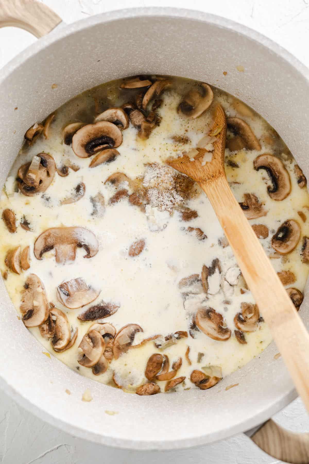 sautéing mushroom and garlic with cream on a pan
