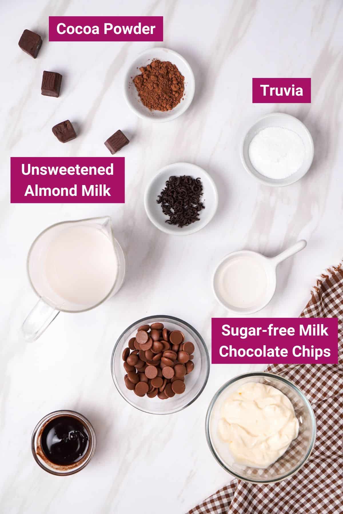 ingredients needed to make keto hot chocolate: unsweetened almond milk, sugar free choco chips, truvia and cocoa powder on separate bowls