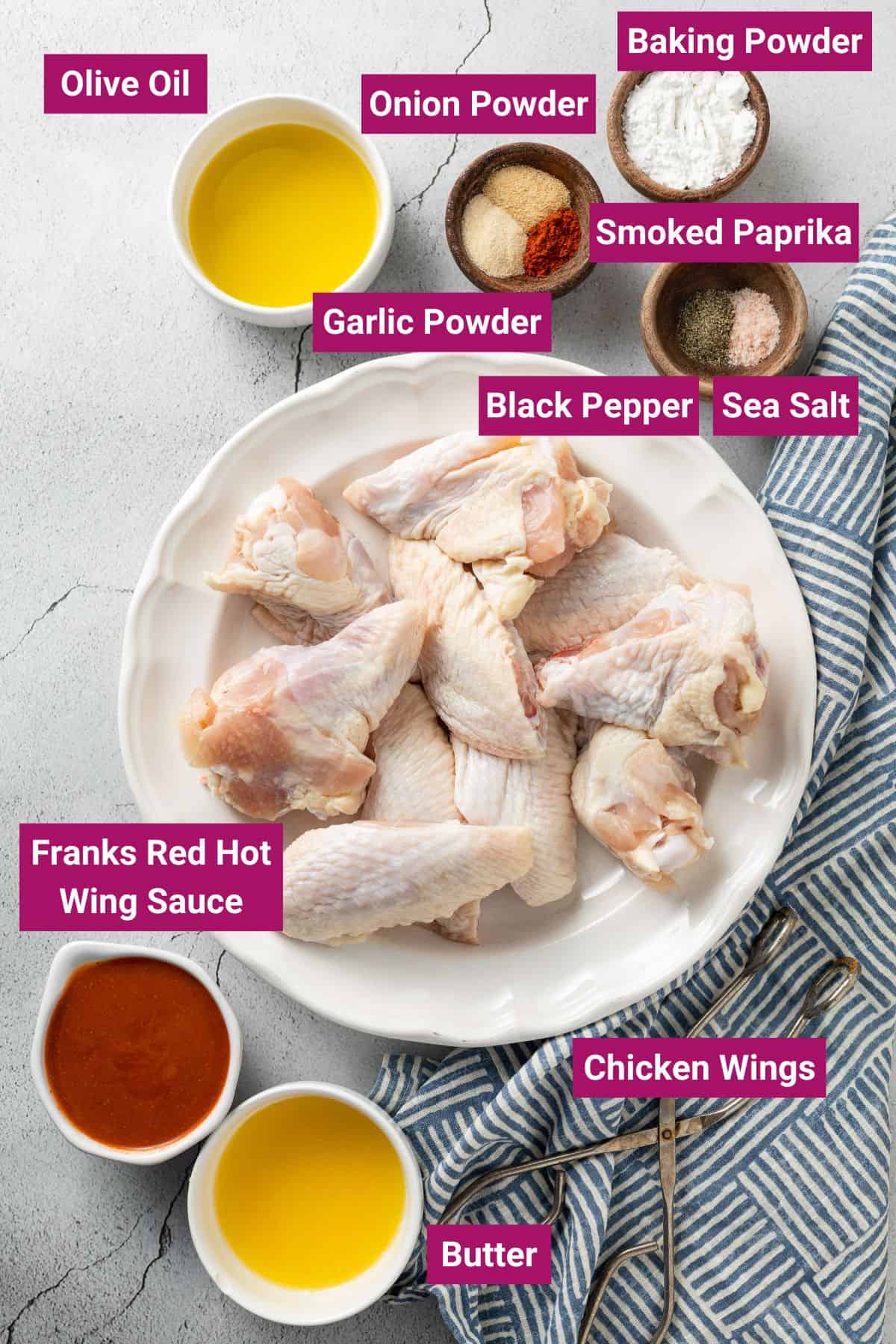 ingredients needed to make crispy buffalo wings: olive oil, spices, black pepper, sea salt, hot wings sauce, chicken wings, melted butter on separate bowls