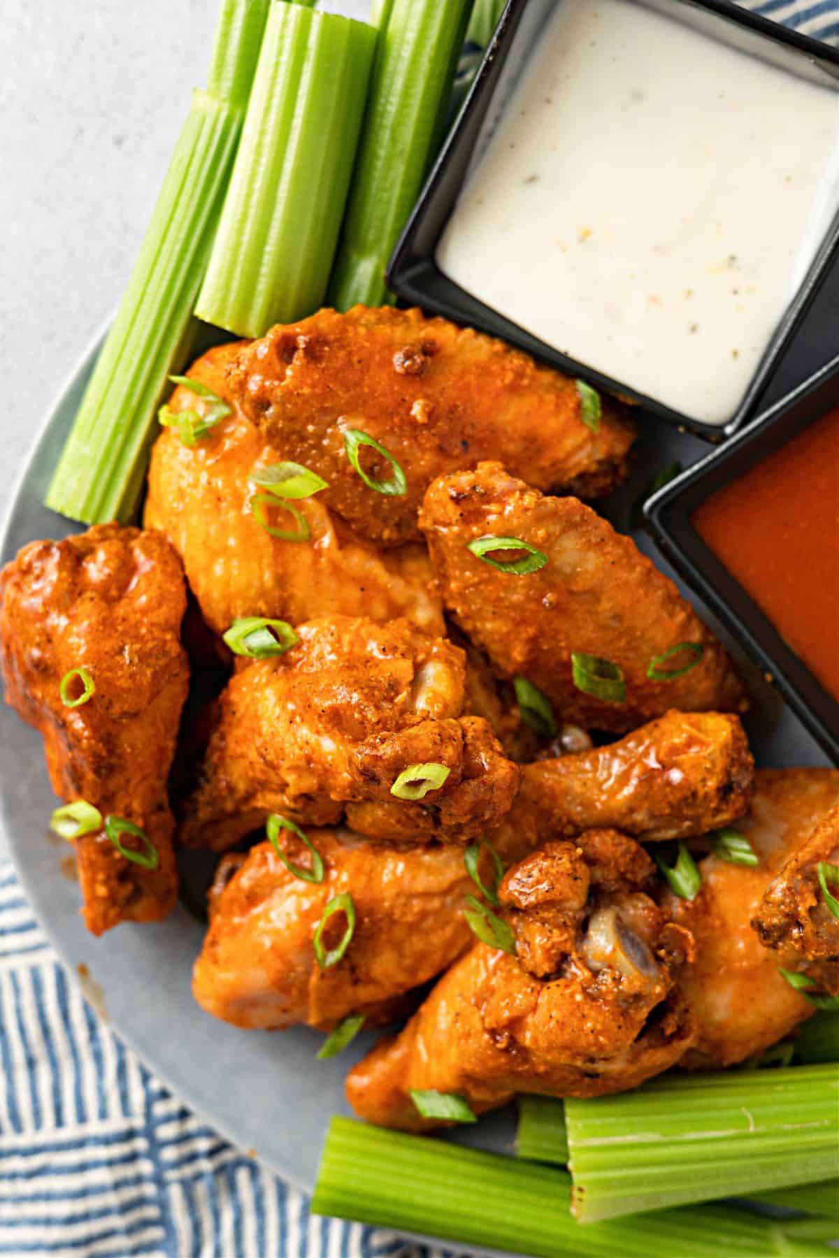 Baked Buffalo Wings, celery and dipping sauce on a plate