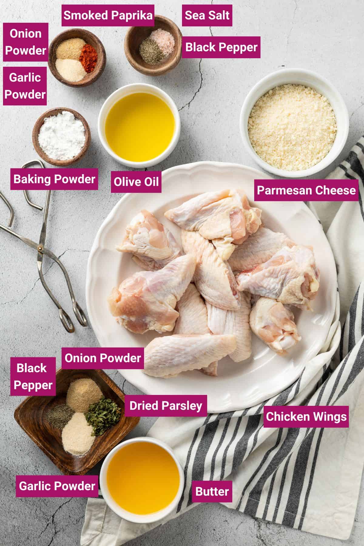 ingredients needed to make baked garlic parmesan wings: Chicken Wings, Sea Salt, Black Pepper, Smoked Paprika, Garlic Powder, Onion Powder, Baking Powder, Olive oil and other spices on separate bowls