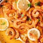 close up shot of baked shrimp topped with slices of lemon