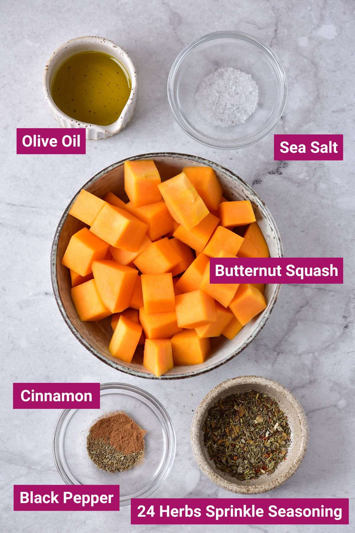 ingredients needed to air fry butternut squash: olive oil, sea salt, diced butternut squash, cinnamon, black pepper, herb sprinkle seasoning on separate bowls