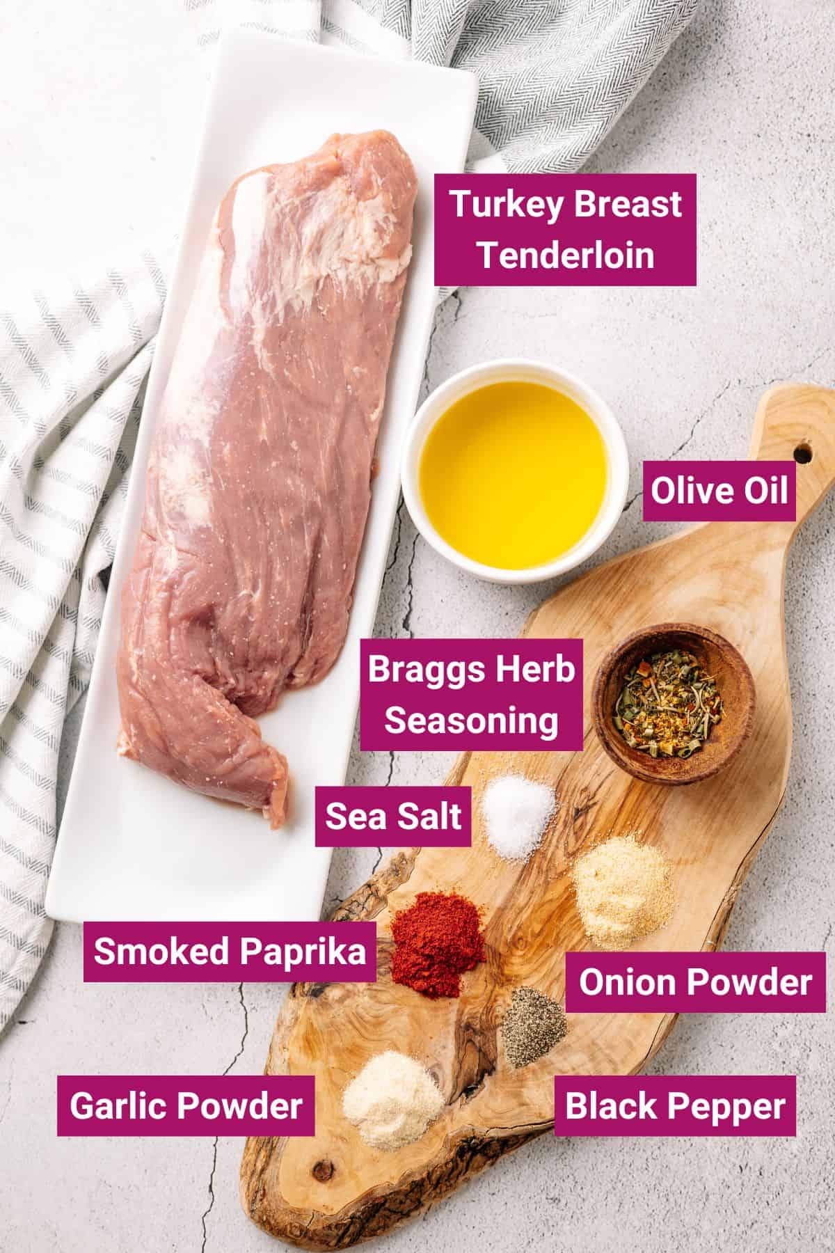 Turkey breast tenderloins, braggs herb seasoning, onion powder, garlic powder, smoked paprika, black pepper, sea salt, olive oil on a wooden chopping board