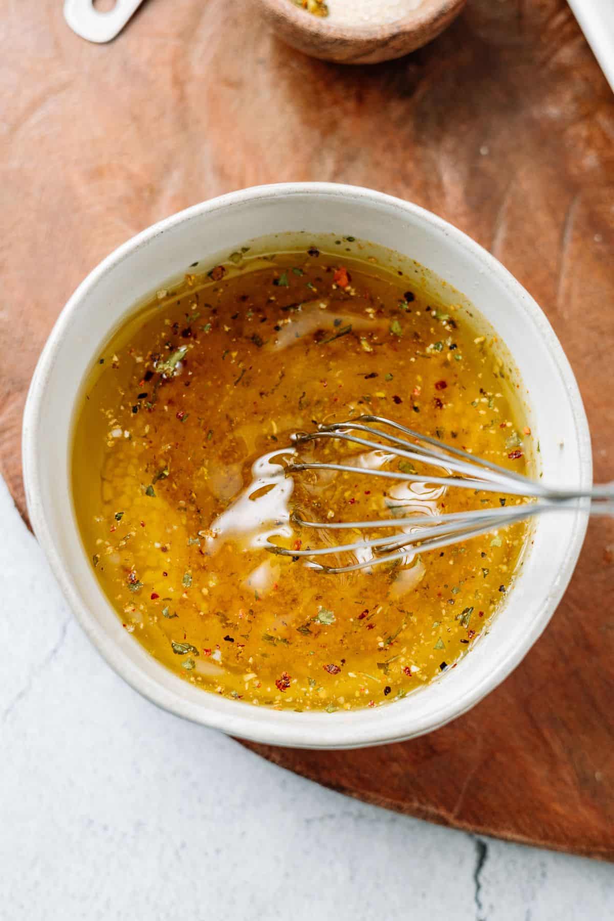 whisking ingredients of marinade on a bowl