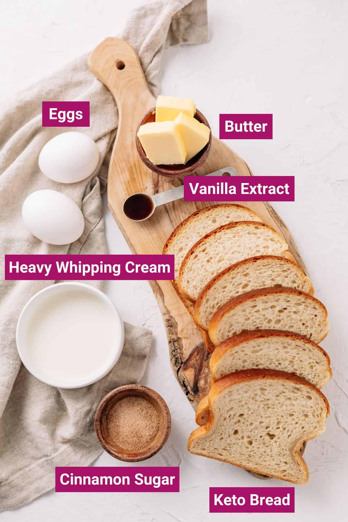 ingredients needed to make keto French toast: butter, eggs, vanilla extract, whipping cream, cinnamon sugar on separate bowls and keto bread on a chopping board