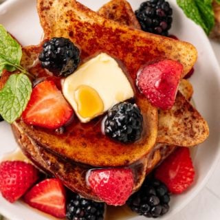 Stuffed French Toast topped with butter, strawberries, maple syrup and blueberries