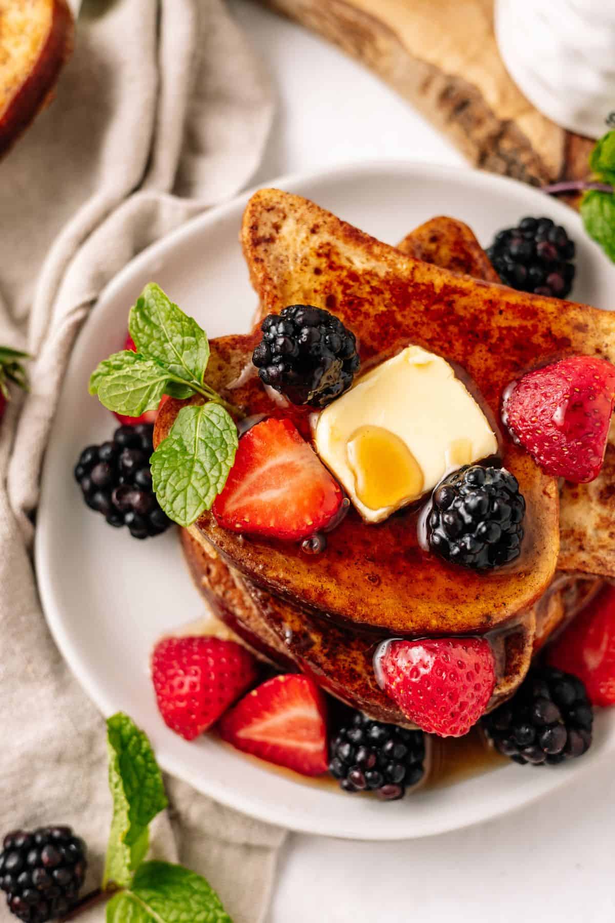 keto French Toast on a plate with fresh berries and keto maple syrup