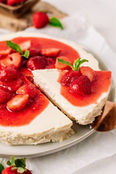 getting a slice of strawberry cheesecake from the plate
