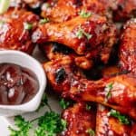 close up of crockpot bbq wings on a plate with barbecue sauce