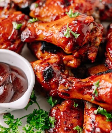 close up of crockpot bbq wings on a plate with barbecue sauce