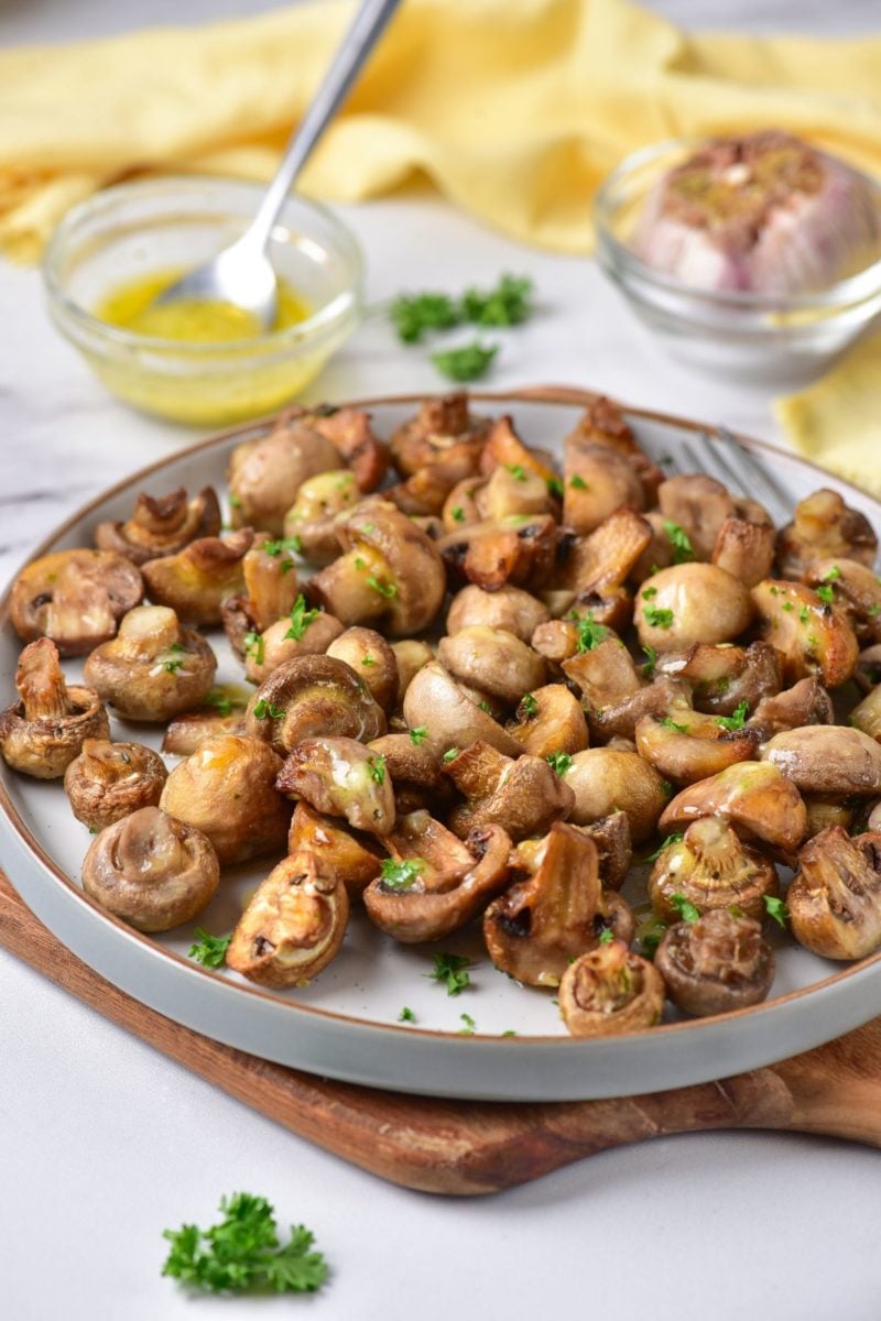 roasted garlic mushrooms on a large plate topped with parsley