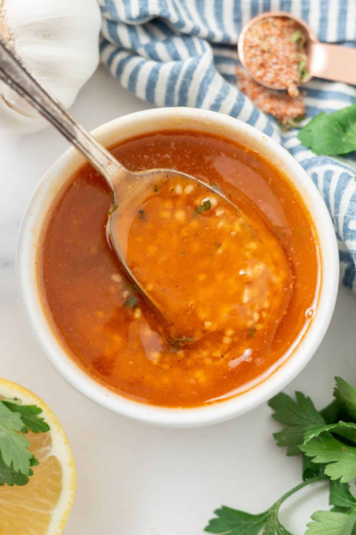 a spoon of Cajun Garlic Butter Sauce in a small bowl