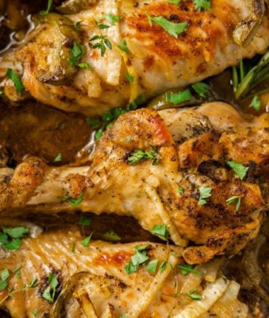 Close up overhead view of a cooked turkey wing garnished with parsley, next to two more wings