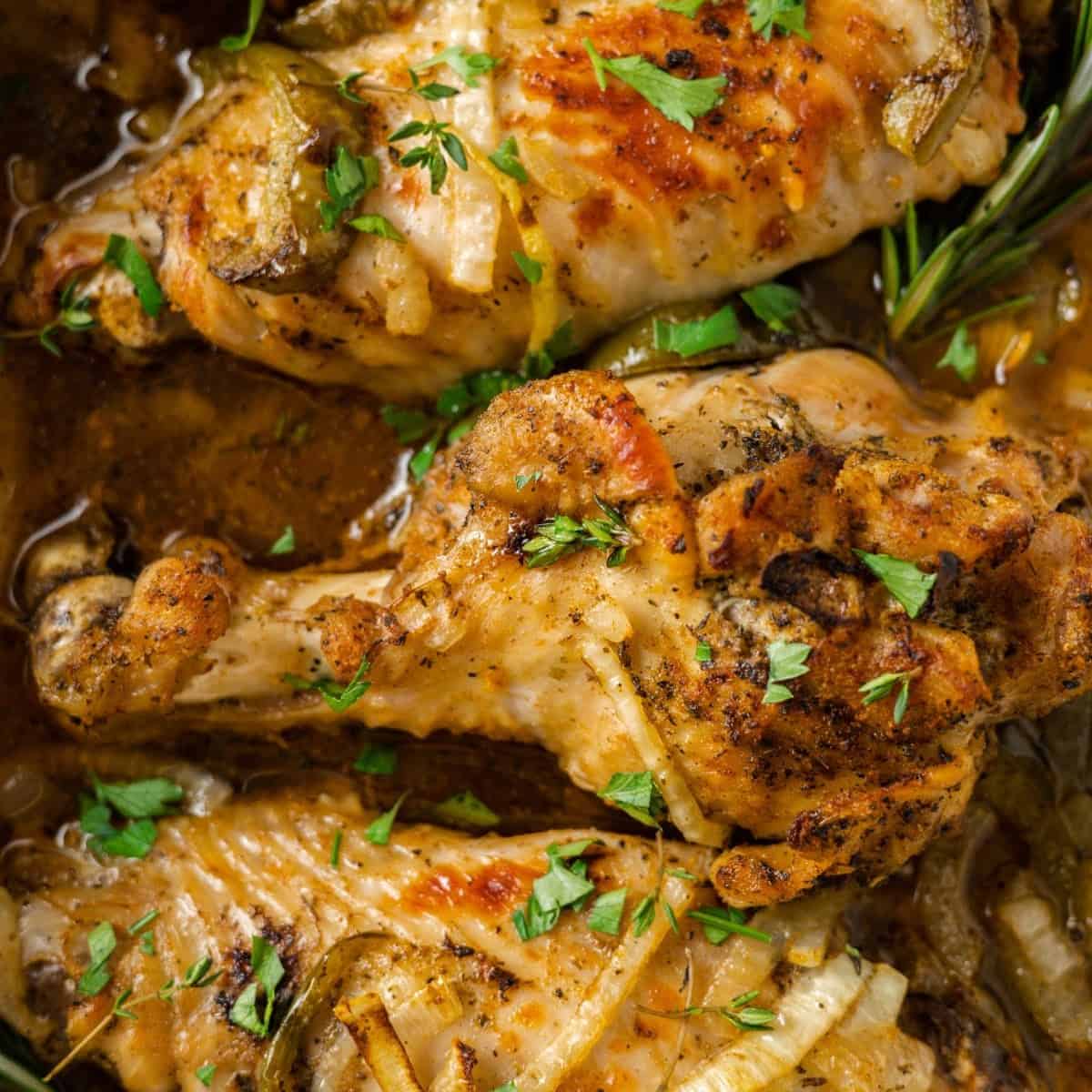 Close up overhead view of a cooked turkey wing garnished with parsley, next to two more wings