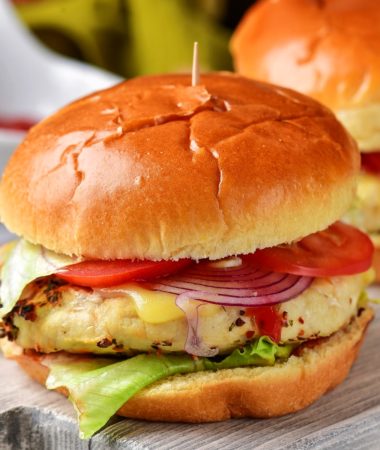 air fryer frozen turkey burger patties on a bun with cheese, lettuce, tomatoes, red onions, and ketchup