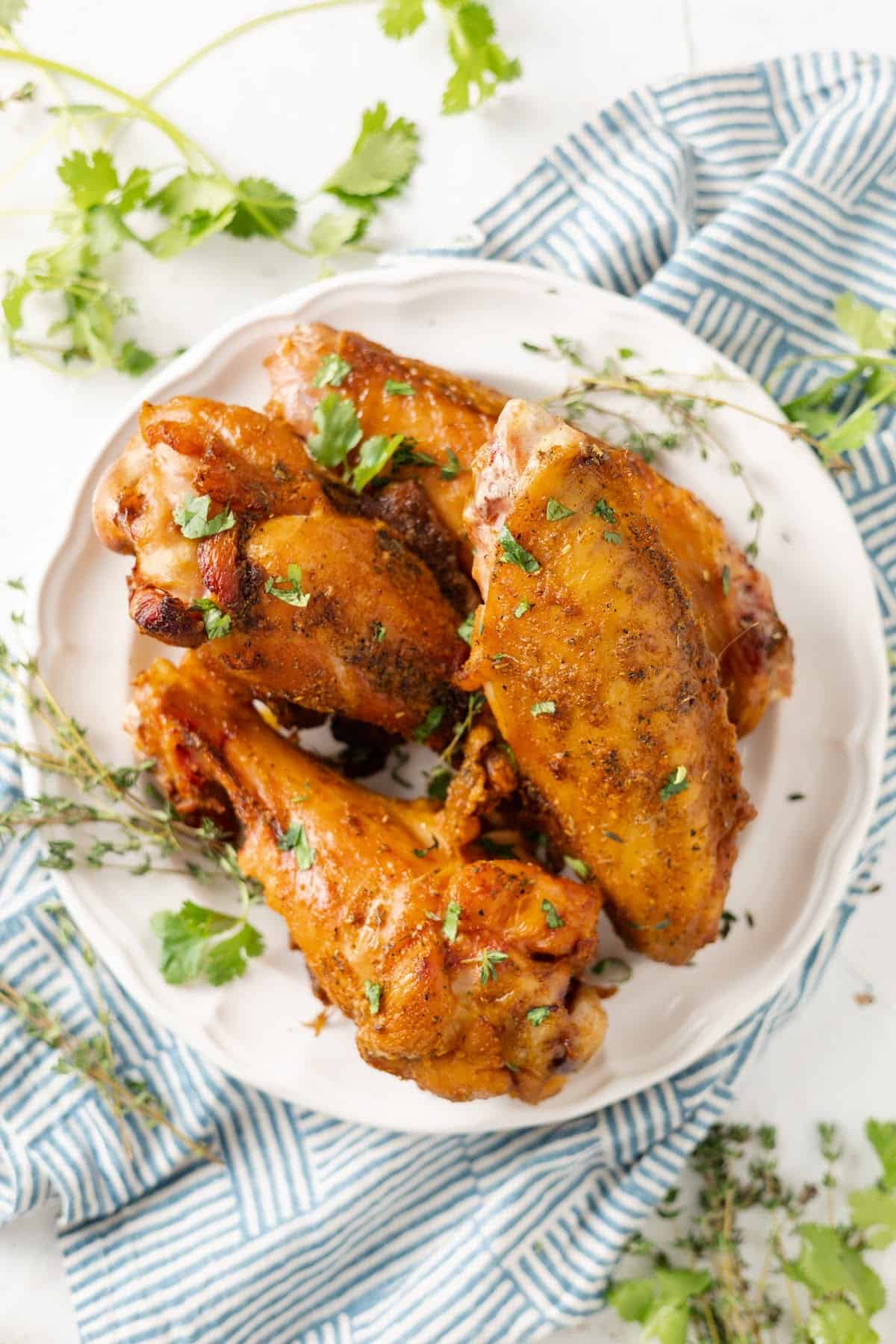 Overhead view of a plate of turkey wings, surrounded by parsley