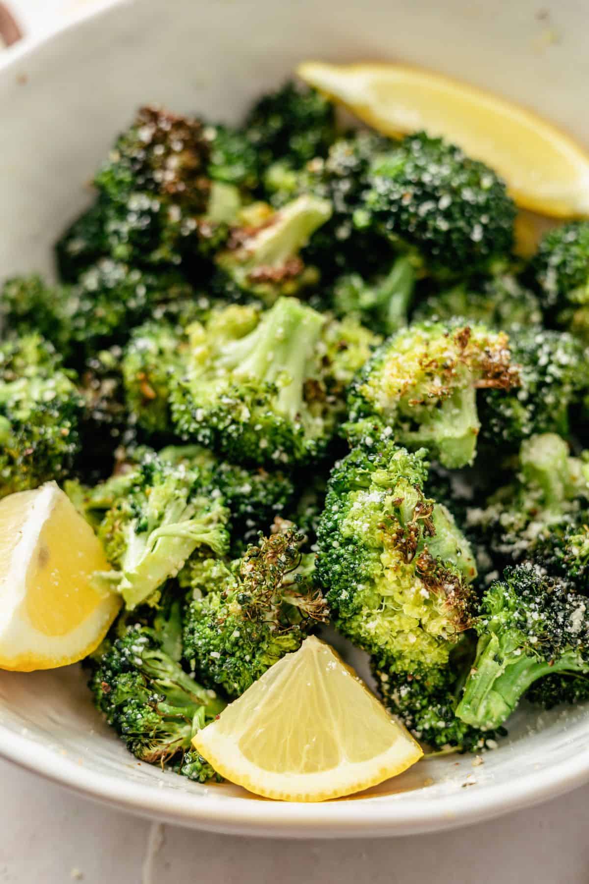 cooked and seasoned Broccoli on a large bowl with some slices of lemon