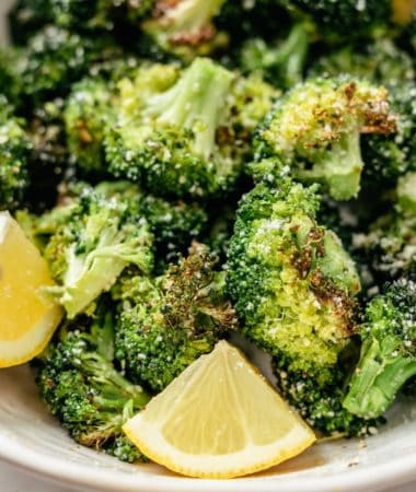 ninja air fryer broccoli on a plate with lemon slices