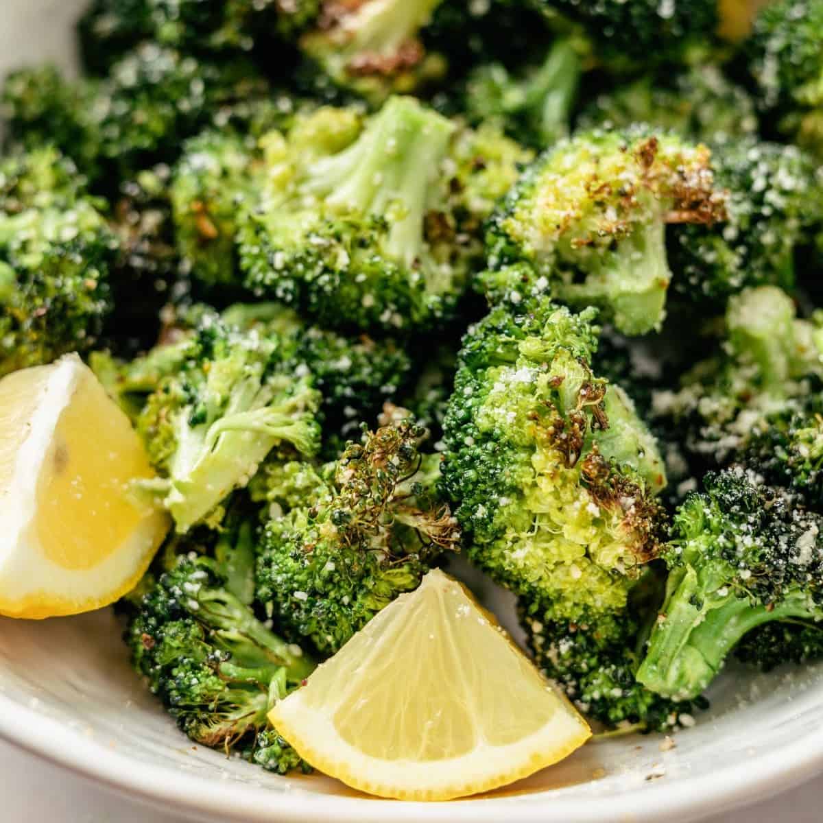 ninja air fryer broccoli on a plate with lemon slices