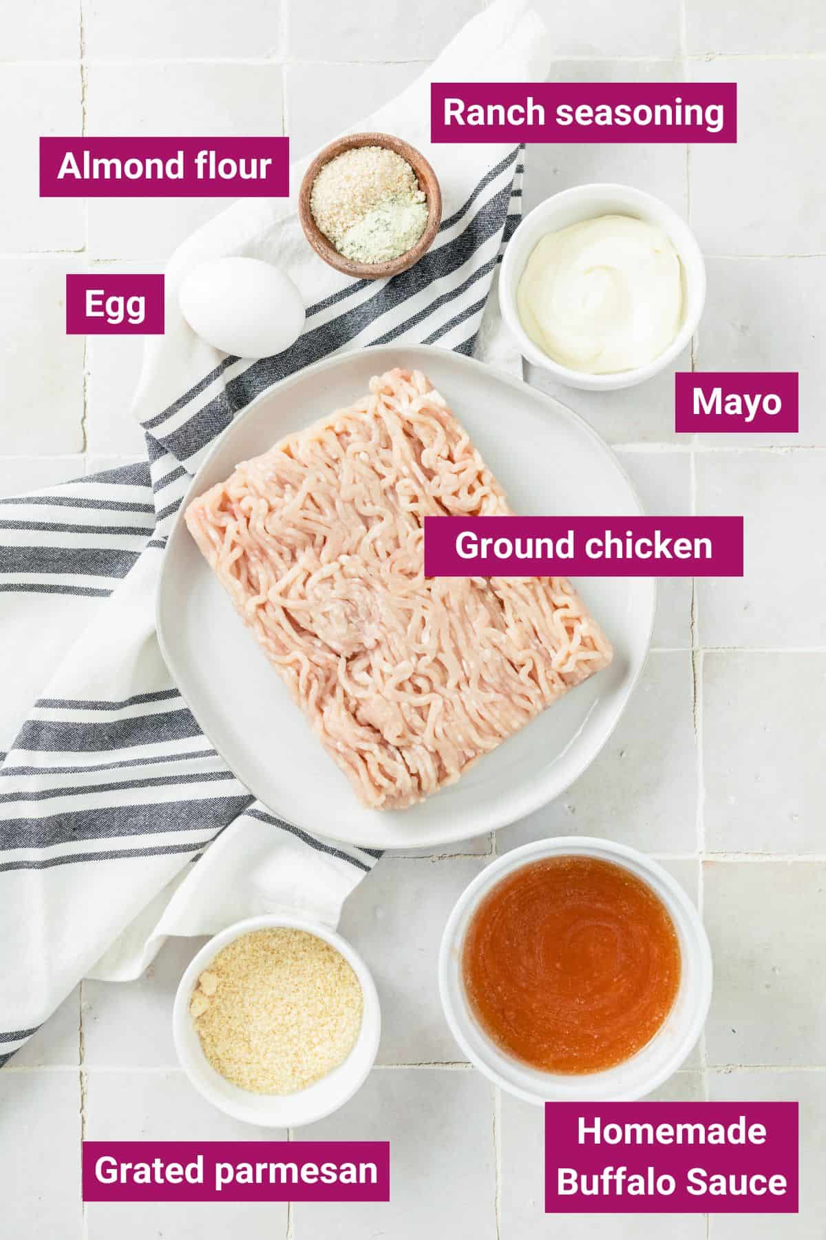 ingredients needed for buffalo chicken meatballs without breadcrumbs in separate bowls: egg, almond flour, ranch seasoning, mayonnaise, ground chicken, buffalo sauce, and grated parmesan.